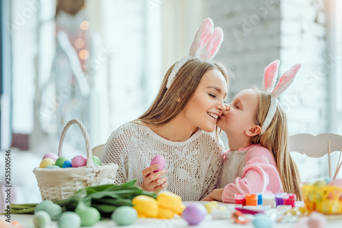 Mom, thank you for making Easter preparation so interesting and fun.Mom and daughter are preparing for Easter together.On the table is a basket with Easter eggs, flowers and paint.