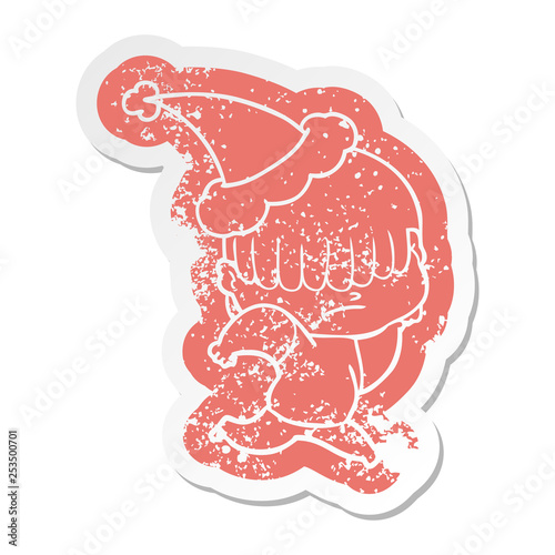 cartoon distressed sticker of a boy with untidy hair wearing santa hat
