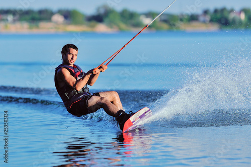 Wakeboarder surfing across a lake photo