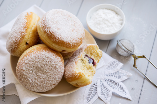 Traditional German Polish Donut with Raspberry Jam Dusted with Icing Sugar. Traditional meal on Fat Thursday, the last day of the carnival. photo