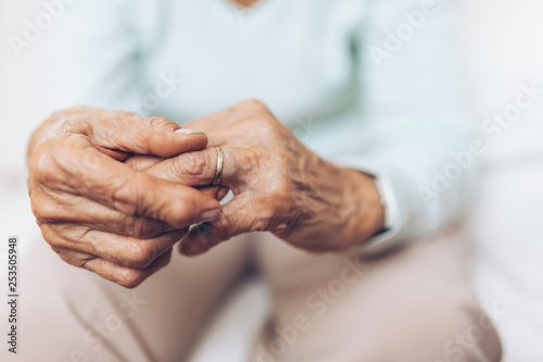 Heartbroken elderly woman holding a wedding ring