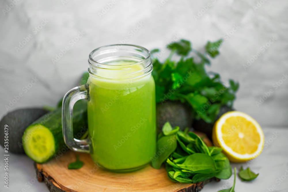 Green smoothie. Healthy green detox smoothie glass with spinach, lemon, cucumber, lemon and avocado, healthy organic food