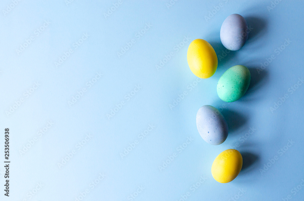 A row of multi-colored Easter eggs on a blue background.