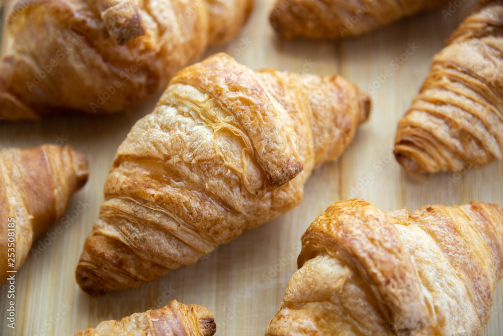 Group of fresh baked croissants on wooden board