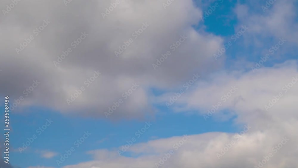 Clouds running across the blue sky. . Cumulus clouds form against a brilliant blue sky. Timelapse of white clouds with blue sky in background Clouds running across the blue sky. . Cumulus clouds form against a brilliant blue sky. Timelapse of white clouds with blue sky in background