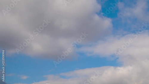 Clouds running across the blue sky. . Cumulus clouds form against a brilliant blue sky. Timelapse of white clouds with blue sky in background photo