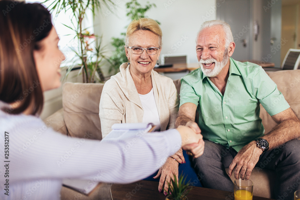 Positive aged couple consulting with insurance agent Positive aged couple consulting with insurance agent