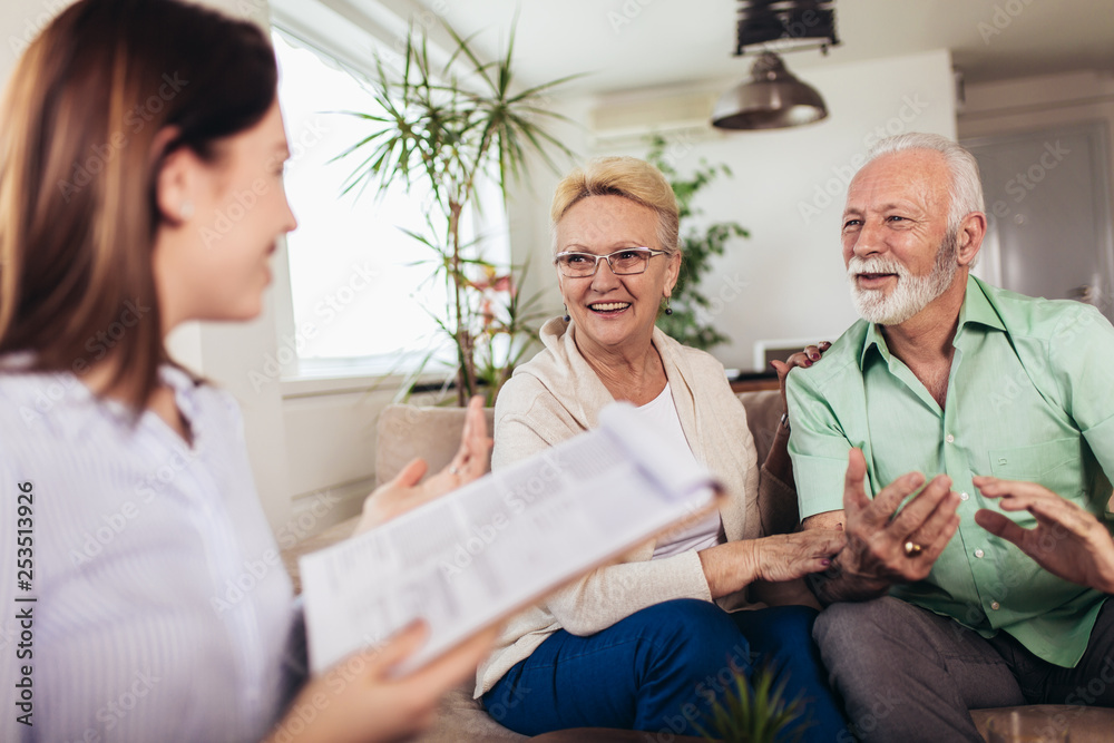 Obraz premium Positive aged couple consulting with insurance agent