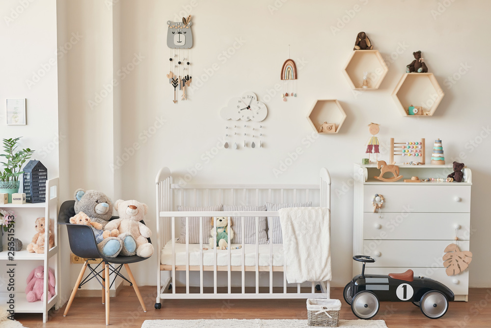 Φωτογραφία wooden toys in the children's room, chest of drawers and a white bed, the interi