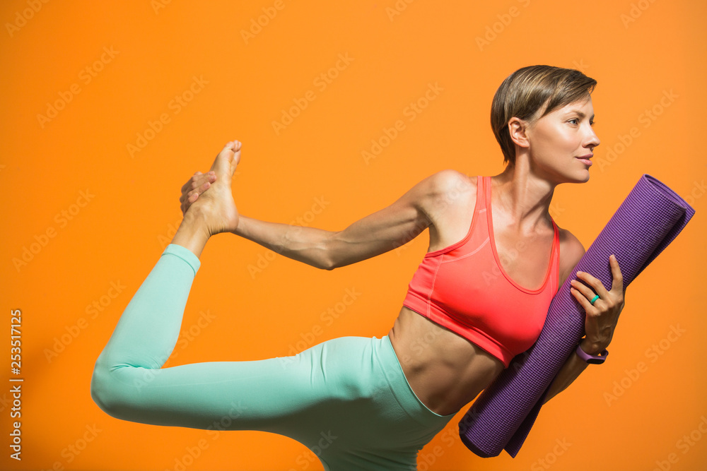 Sporty yoga girl with yoga mat isolated over bright background Sporty yoga girl with yoga mat isolated over bright background