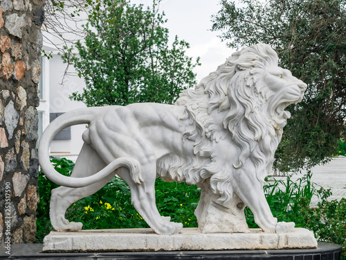 City sculpture of a white lion with open mouth at the entrance. Local landmark