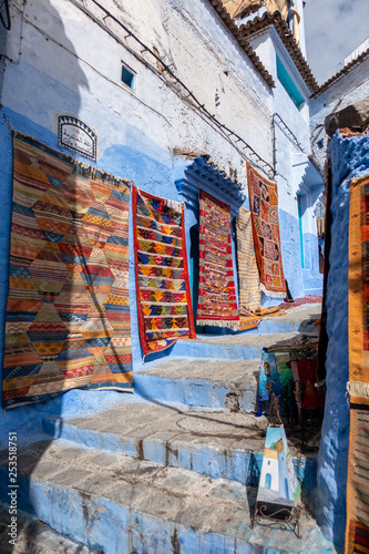 A vendor is selling some rugs in the streets of Chefchaouen, Morocco © Michael