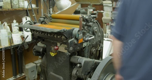 A Heidelberg platen letterpress printing press in operation ready to print with yellow ink. photo