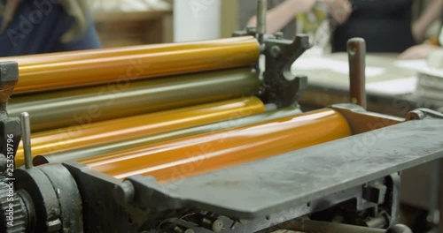 Letterpress printing machine inking rollers with yellow ink. Heidelberg platen press. photo