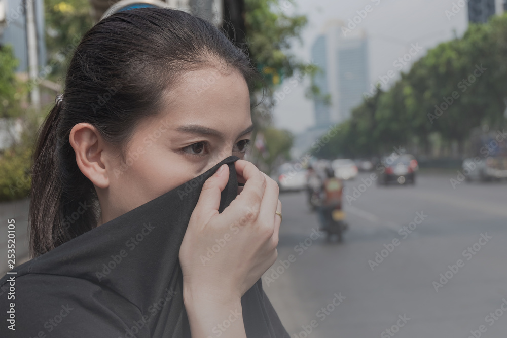 woman closes her nose with hand because of bad traffic pollution woman closes her nose with hand because of bad traffic pollution