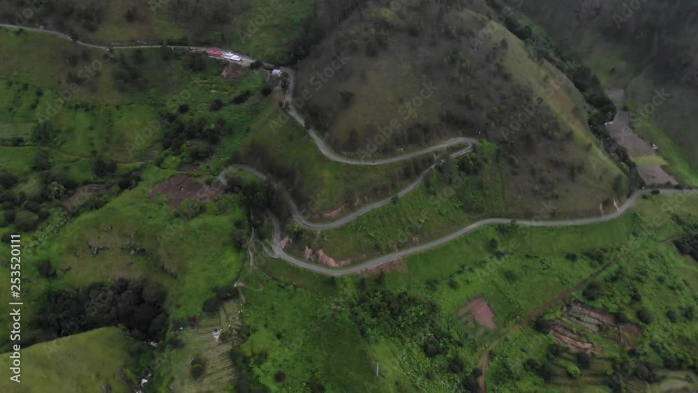 Aerial drone shot with slow tilt down of windy road in the mountains at Lake Toba in Sumatra, Indonesia. Aerial drone shot with slow tilt down of windy road in the mountains at Lake Toba in Sumatra, Indonesia.