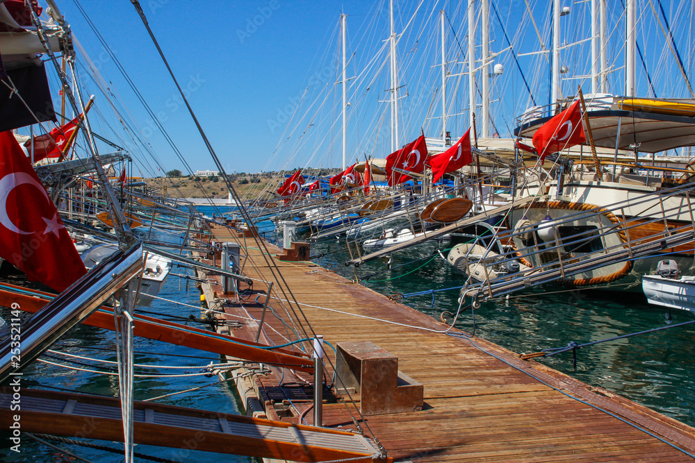 Port with yachts standing in a row with Turkish flags