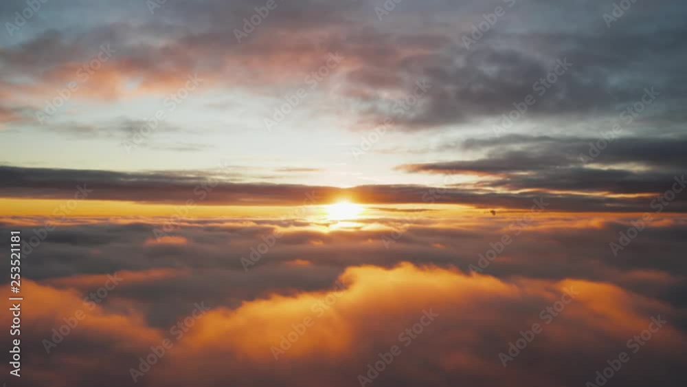 Aerial pilots view flying above fluffy clouds that are being illuminated by a beautiful sunset. Aerial pilots view flying above fluffy clouds that are being illuminated by a beautiful sunset.