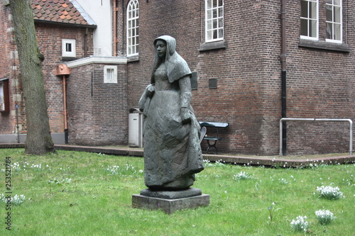 secret garden of the beghine of amsterdam. statue in the middle of the green in the reserved and silent neighborhood inhabited by religious people