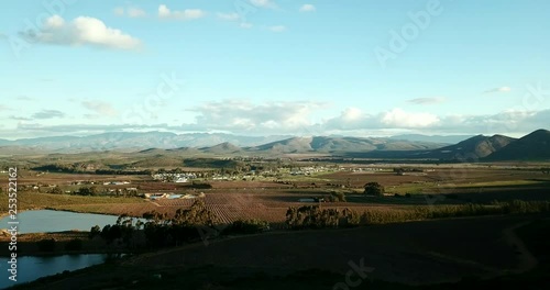 Overlooking a valley with farmland and a rural town in South Africa with dams in the foreground slow pan left photo