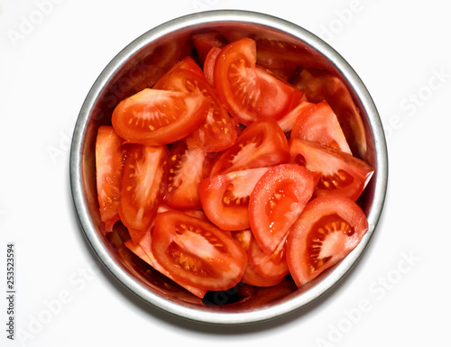 Tomatoes in a metal bowl on white background. Top view.