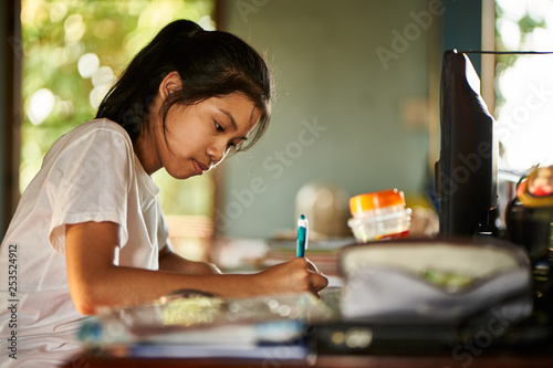 thai teen girl doing homework and studying at home