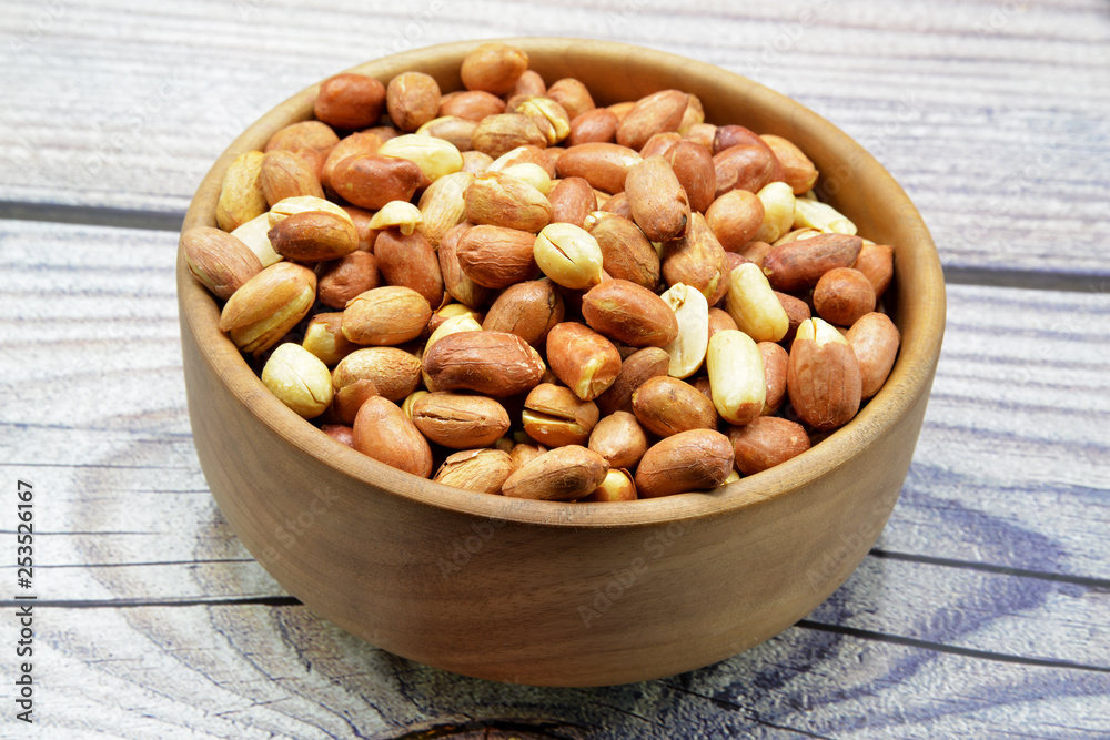 peanuts in bowl on wooden background peanuts in bowl on wooden background