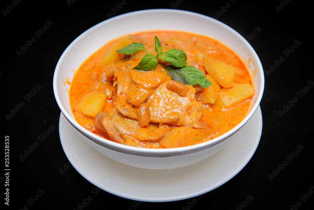 Close up Muslim style chicken and potato curry or chicken mussaman curry , isolate black background Close up Muslim style chicken and potato curry or chicken mussaman curry , isolate black background