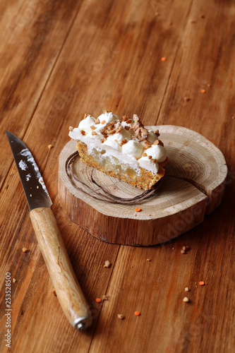 Carrot Cake with Apple Filling and Cream Cheese Frosting, on wooden table.