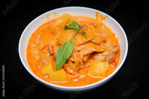 Close up Muslim style chicken and potato curry or chicken mussaman curry , isolate black background