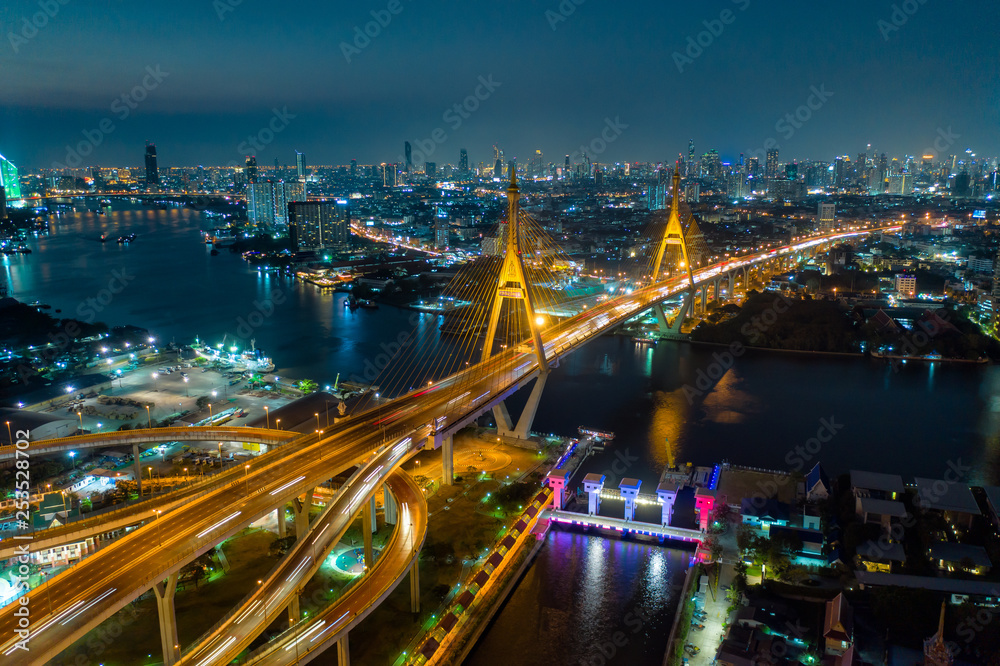 Fototapeta premium Widok z lotu ptaka na wiszący most Bhumibol krzyż nad rzeką Menam w Bangkoku z samochodu na moście w nocy w Bangkoku w Tajlandii.