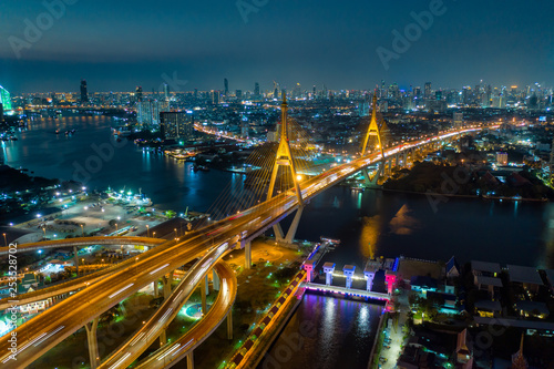 Aerial view of Bhumibol suspension bridge cross over Chao Phraya River in Bangkok city with car on the bridge at night in Bangkok Thailand. © Travel man