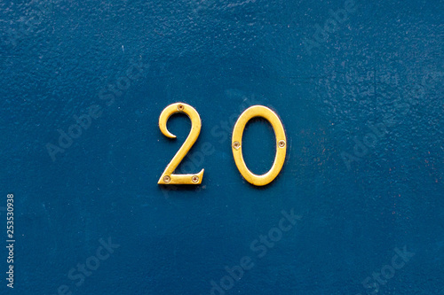 House number 20 in bronze numerals on a blue painted wall photo