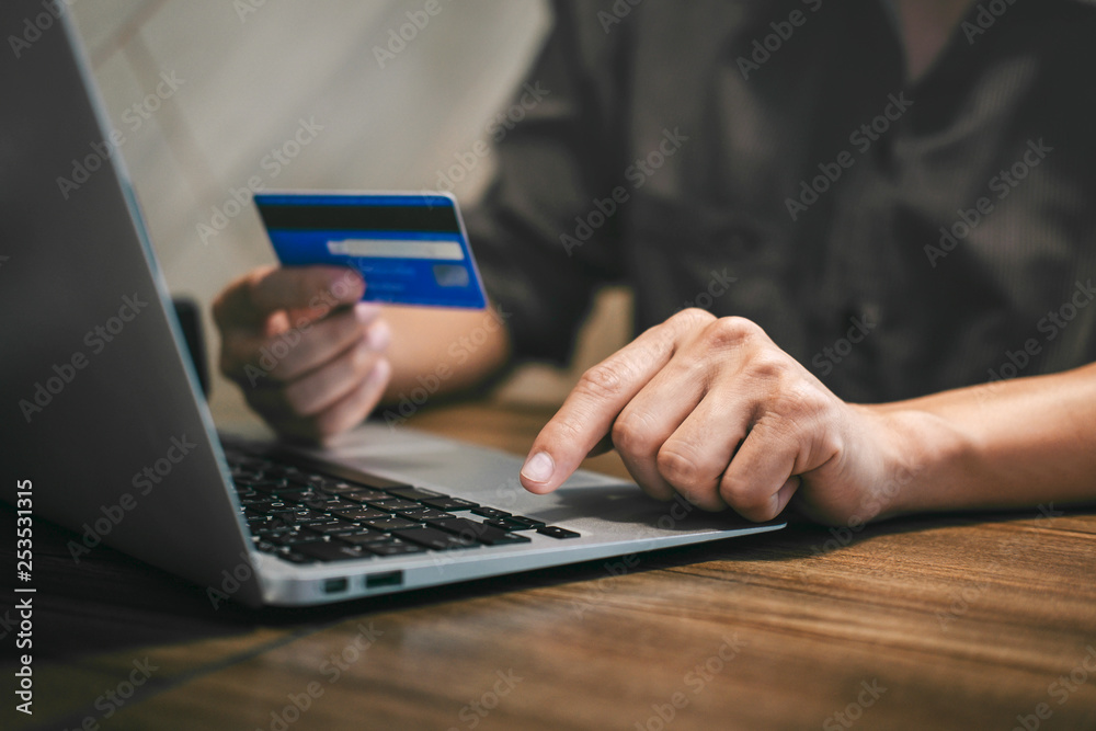 Φωτογραφία Businessman holding credit card and typing on laptop for online shopping and pay
