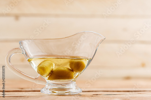 Olive oil in a beautiful oil can on a wooden background