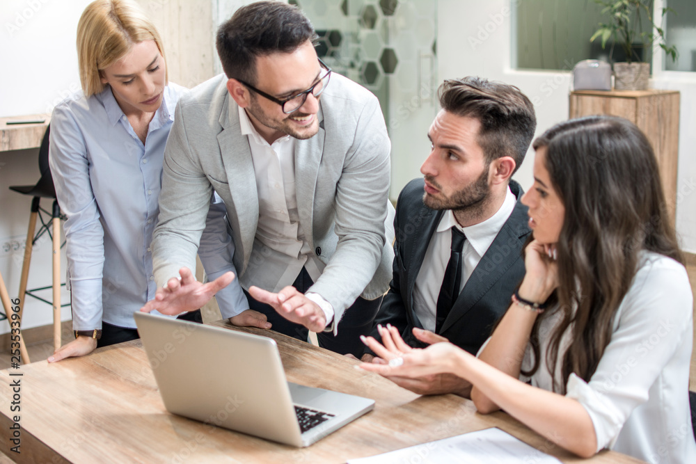 Εκτύπωση καμβά Businessmen and businesswoman working together with laptop in boardroom during b