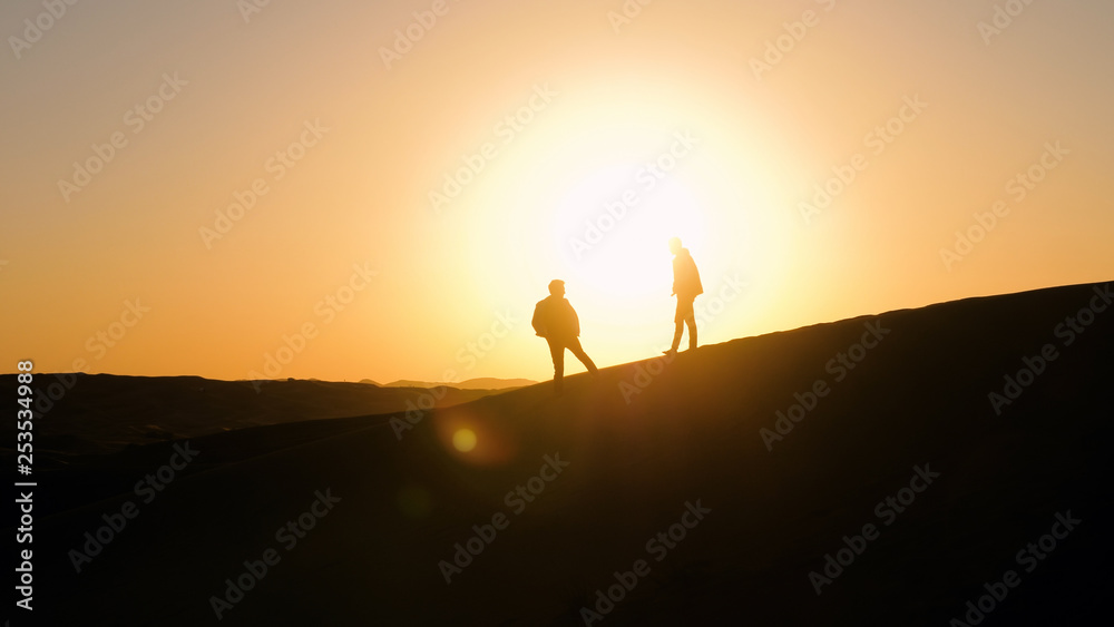 Silhouettes of men against sunset