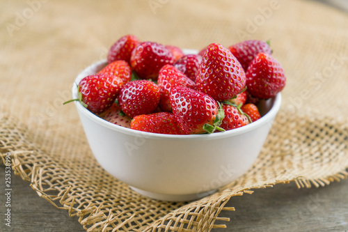 Strawberry in bowl on sackcloth.