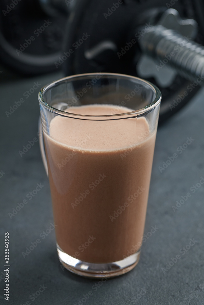 Chocolate Protein Shake and Dumbbells. Nutrition for bodybuilding. Black stone background. Copy space. Chocolate Protein Shake and Dumbbells. Nutrition for bodybuilding. Black stone background. Copy space.
