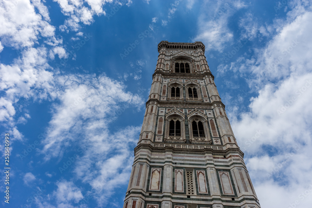 Italy,Florence, Giotto's Campanile, a tall clock tower sitting under a cloudy blue sky with Giotto's Campanile in the background