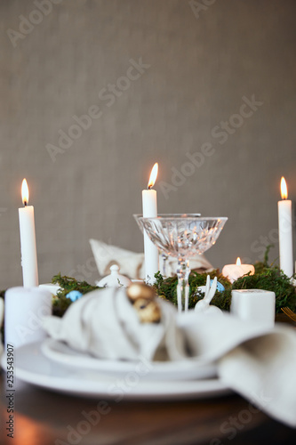 selective focus of candles and crystal glass on wooden table at home photo