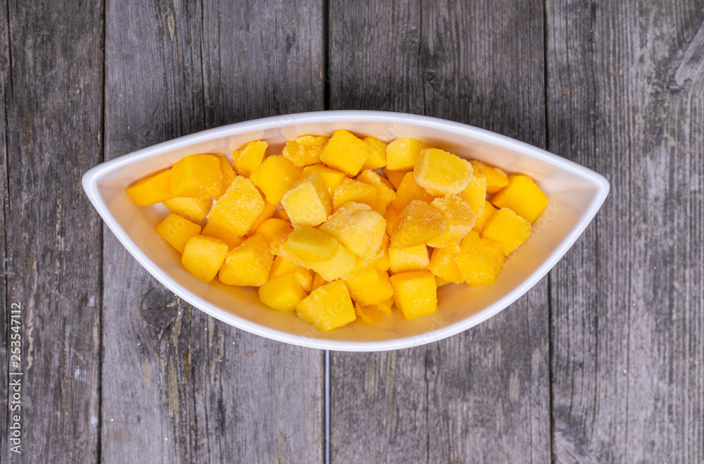 fresh cutted mango in a shaped bowl on wooden table fresh cutted mango in a shaped bowl on wooden table