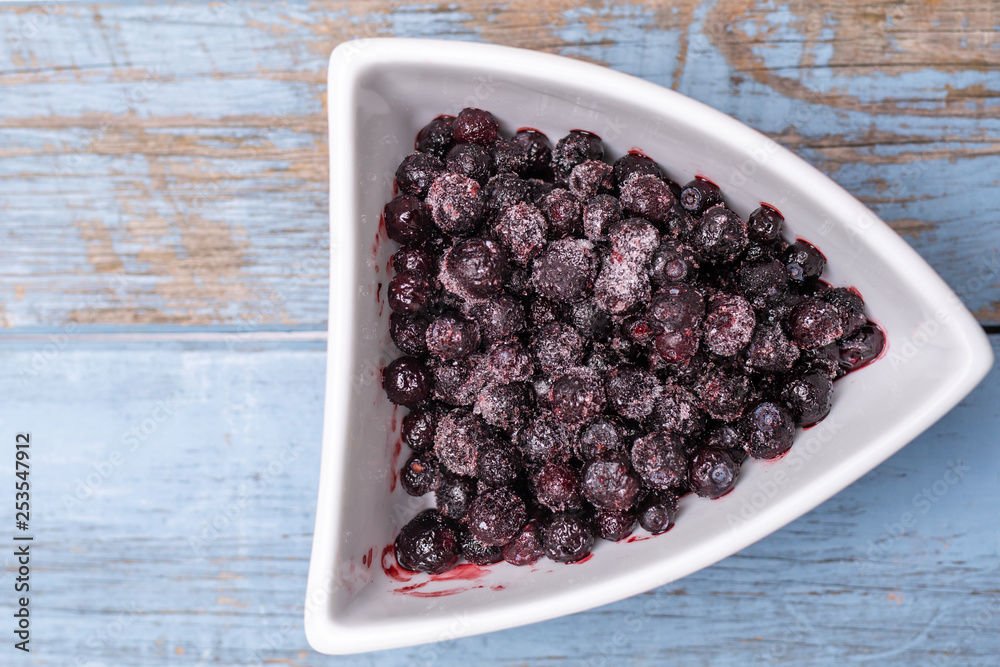 blueberries in a shaped bowl on wooden background blueberries in a shaped bowl on wooden background