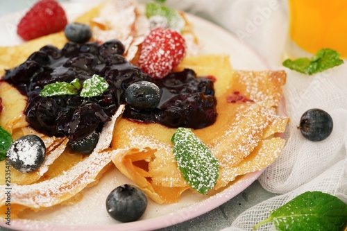 French crepes with blueberry compote topping, selective focus