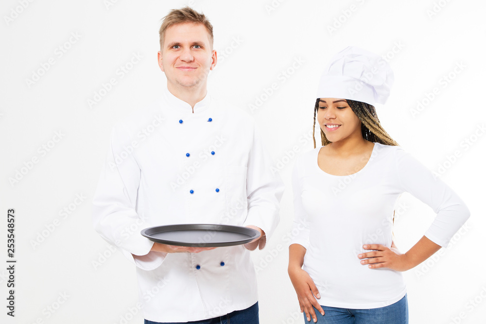 smile black female and white male chefs cooks hold an empty tray isolated on white background smile black female and white male chefs cooks hold an empty tray isolated on white background