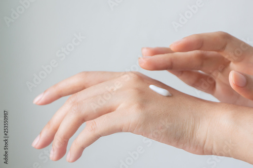 Woman hands applying hand cream.