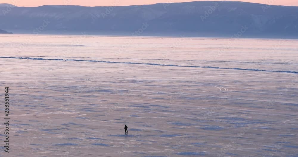 Silhouette Of A Man Skating On The Surface Of The Ice-covered Lake Baikal, Siberia, Russia. Silhouette Of A Man Skating On The Surface Of The Ice-covered Lake Baikal, Siberia, Russia.