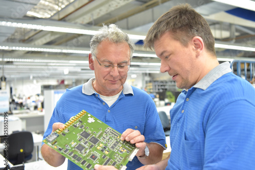 Fertigung von Elektronik: Teamwork Besprechnung und Qualitätskontrolle in einer Hi Tech Fabrik // Manufacturing of electronics: Teamwork discussion and quality control in a Hi Tech factory photo