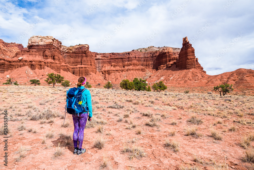 Young woman is looking at the Chimney Rock in Capitol Reef National Park, Utah, USA