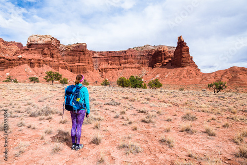 Young woman is looking at the Chimney Rock in Capitol Reef National Park, Utah, USA